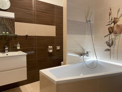 a bathroom with a bath tub and a sink at Hotel Herman in Rychnov nad Kněžnou