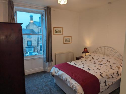 a bedroom with a bed and a large window at Market Place Flats in Barnard Castle