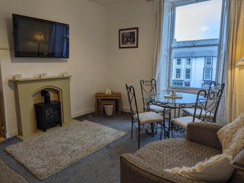 a living room with a fireplace and a table with chairs at Market Place Flats in Barnard Castle