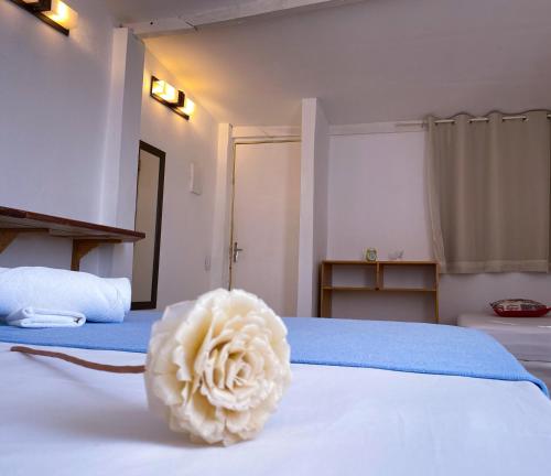 a white flower sitting on top of a bed at Casarão Jeri in Jericoacoara