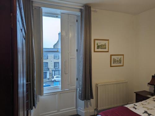 a bedroom with a window with a view of a building at Market Place Flats in Barnard Castle