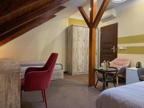リフノフ・ナト・クニェジュノウにあるHotel Hermanのベッド、テーブル、椅子が備わるホテルルームです。
