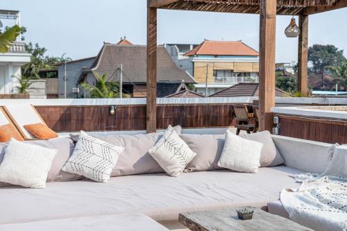 a white couch on a patio with pillows at Sunset Villa in Munggu
