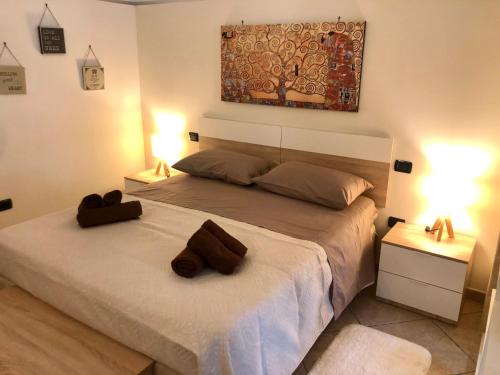 a bedroom with a bed with two brown towels on it at Happy Loft Salento in Cellino San Marco