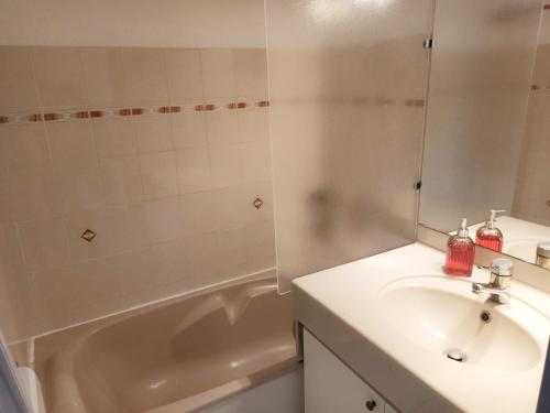 une salle de bain blanche avec un lavabo et une baignoire dans l'établissement A PIEDS NUS JUSQU'A LA MER, à Six-Fours-les-Plages