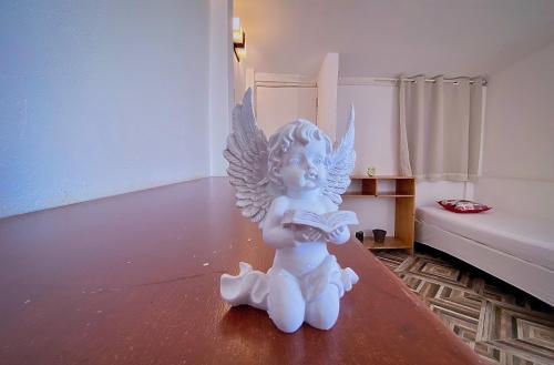 a white angel statue sitting on a table reading a book at Casarão Jeri in Jericoacoara