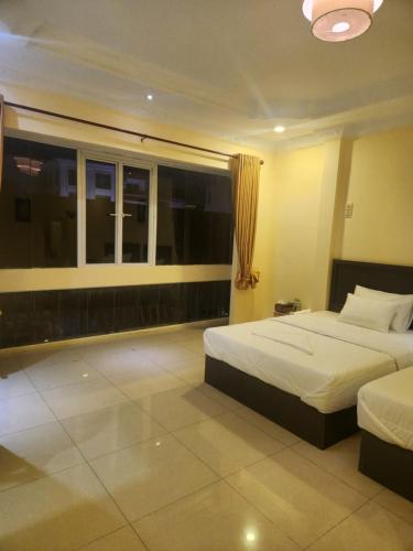a hotel room with two beds and a window at Somato Hotel in Phnom Penh