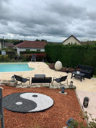 une cour avec une piscine, des chaises et une table dans l'établissement UNE AGREABLE CHAMBRE INDEPENDANTE, à Rilhac-Rancon