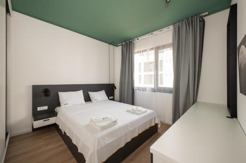 a bedroom with a large bed and a window at Citadel Apartments in Timişoara