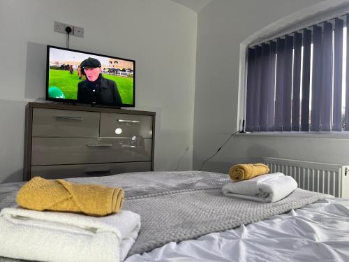 a bedroom with a tv and a bed with towels at The Annexe, St Andrews house hotel, Two bedrooms Sleeps 4 in Preston