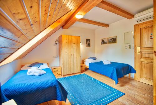 two beds in a room with wooden ceilings at Apartmán-Hotel Jítravský Dvorec in Rynoltice