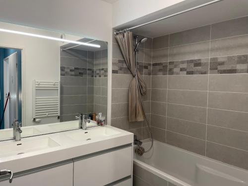y baño con lavabo blanco y espejo. en Duplex NEUF 90 m2 - 3 chambres, avec jardin à Sartrouville, en Sartrouville