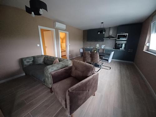 a living room with a couch and a kitchen at Apartman Noel in Izimje