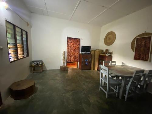 a living room with a table and chairs and a room with a window at Lodge au paradis fleuri 