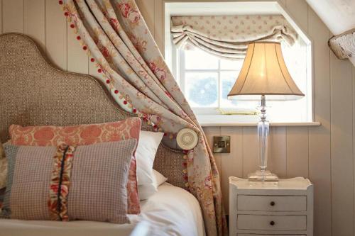 a bedroom with a bed with a window and a lamp at The Dial House in Reepham