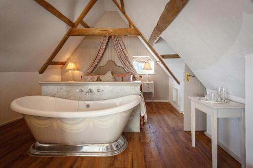 a large bathroom with a large tub in a attic at The Dial House in Reepham