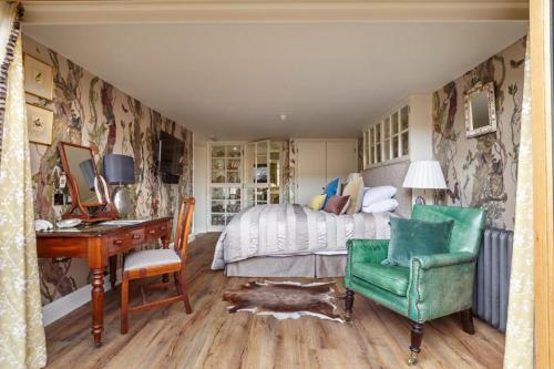 a bedroom with a bed and a desk and a chair at The Dial House in Reepham