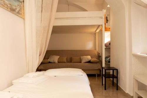 sypialnia z łóżkiem piętrowym i kanapą w obiekcie APPARTAMENTO LA ROCCA w Manerba del Garda