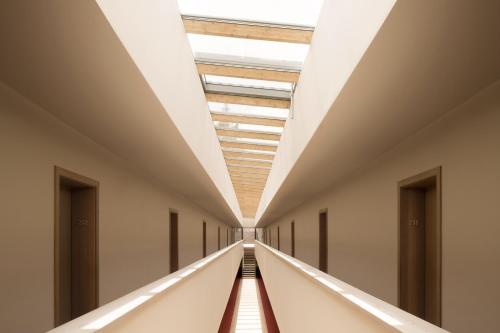 an empty corridor in a building with a ceiling at Vigilius Mountain Resort in Lana