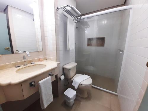 y baño con aseo, lavabo y ducha. en Flat IMPECAVEL proximo aos Shoppings JK e Vila Olimpia, en São Paulo