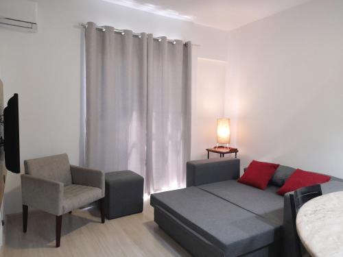 uma sala de estar com uma cama e uma cadeira em Flat IMPECAVEL proximo aos Shoppings JK e Vila Olimpia em São Paulo