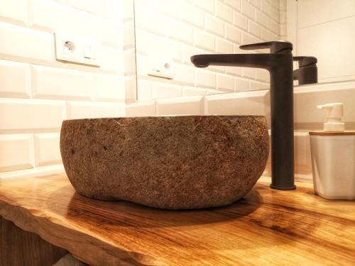 a stone sink on a wooden counter in a bathroom at Cabanela Maitia Apto Matteo Barbacoa in Ribadeo
