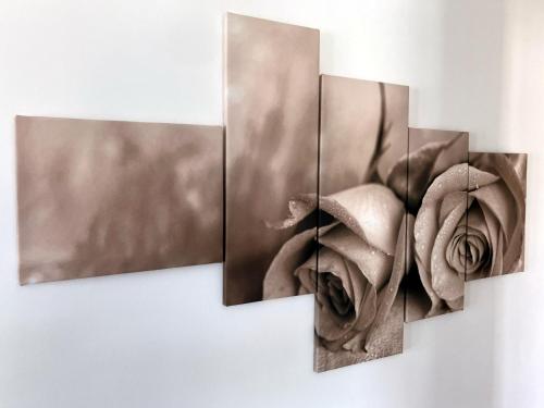 un grupo de cuatro pinturas de flores en una pared en Rosie apartment, en Nova Gorica