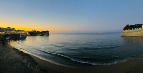 a view of a beach at sunset with the ocean at Yanna's Apartments in Sidari