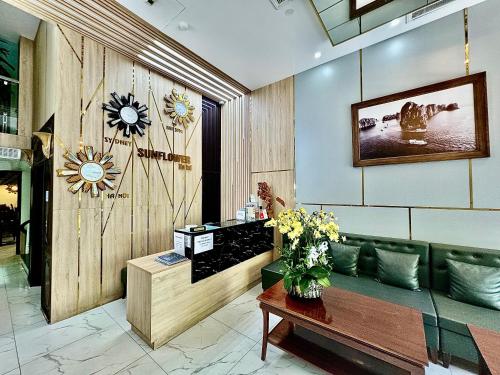 un vestíbulo con un sofá verde y un jarrón de flores en Sunflower Hotel, en Cat Ba