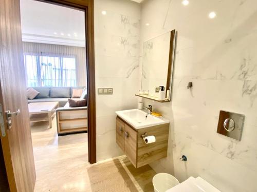 baño con lavabo, espejo y sofá en Résidence Saad, app 53 en Casablanca
