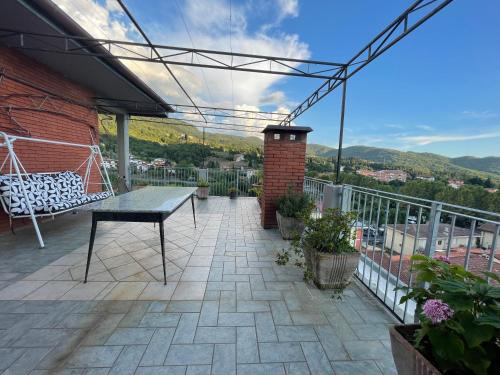 a patio with a table and chairs on a balcony at Tuscany Hills Penthouse in Fivizzano