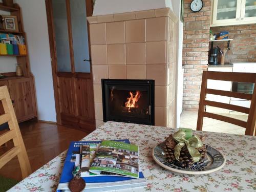 a table with a plate of food and a fireplace at Titi Family Apartman in Bük