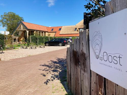 aost sign on a fence in front of a house at Op Oost Boutique hotel & Restaurant het Kook Atelier in Oosterend