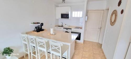 a white kitchen with a counter and a kitchen island at Bella Vista 414-Ocean Lanzamar- Puerto Del Carmen in Tías