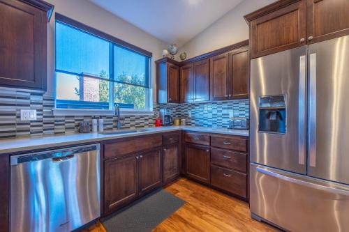 a kitchen with wooden cabinets and a stainless steel refrigerator at Hull Street Loft townhouse in Hood River