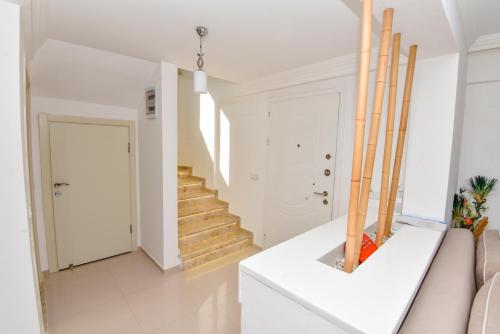 a white living room with stairs and a couch at Villa Rana The Royal Links Sarigerme in Ortaca