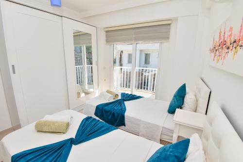 2 Betten in einem Zimmer mit Fenster in der Unterkunft Villa Rana The Royal Links Sarigerme in Ortaca