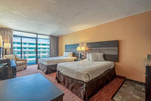 a hotel room with two beds and a couch at Renovated Condo at Landmark Resort, Waterpark View in Myrtle Beach