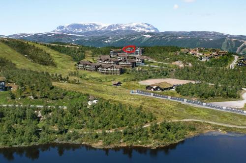 uma vista aérea de um resort com um comboio à beira da água em Kikut Panorama, Geilo - sleeps 9pax, ski in/out - Modern 2 floor apart em Geilo
