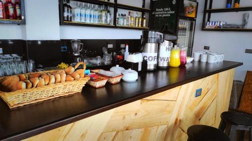 a bar with a counter with baskets of bread at Magic Packer Hostel in Cusco
