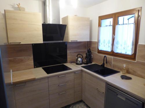 una cucina con un lavello e un piano di lavoro di le chalet Cerdan - classé 3 étoiles - 5 personnes-2 chambres- parking -garage-jardin-WIFI-rénové en 2023 a Bolquere Pyrenees 2000
