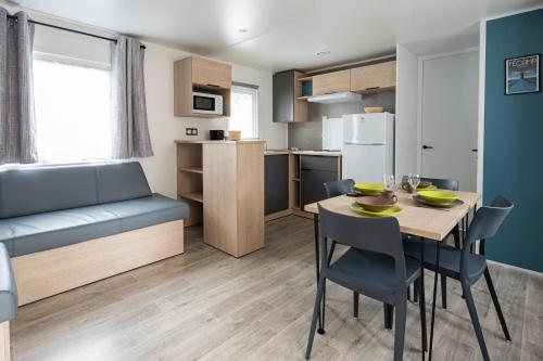 a kitchen and dining room with a table and chairs at Camping les falaises de Toussaint in Toussaint