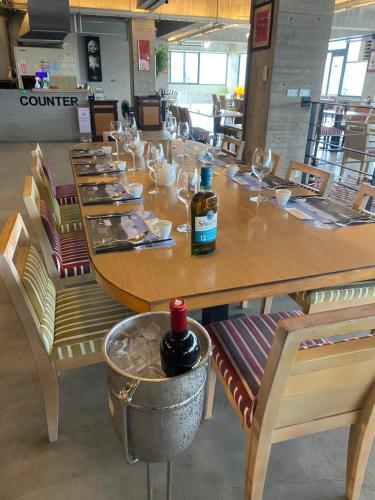 a large wooden table with chairs and a bottle of wine at 森活藝術文旅 in Shiding