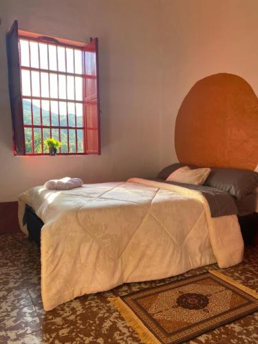 Un dormitorio con una cama grande y una ventana en Habitación Caoba, en Girardota