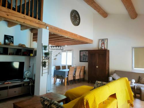 un salon avec un canapé jaune et une table dans l'établissement Mazet et maison du Serre dans les Cévennes, à Monoblet