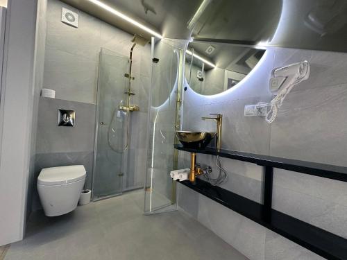 een badkamer met een douche, een toilet en een wastafel bij Restauracja Dajana in Bełchatów