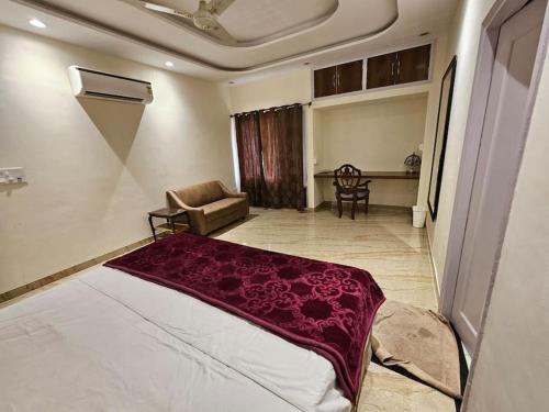 a bedroom with a bed and a chair in a room at Ankhi's Villa with Parking in Amritsar