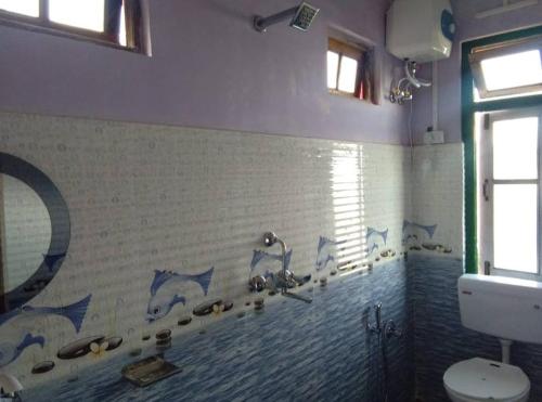uma casa de banho com um mural de peixe na parede em Sunyog Homestay em Pedong