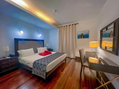sypialnia z łóżkiem i biurkiem oraz łóżko o wymiarach 6 x 6 x 6 w obiekcie Via Mina Hotel w mieście El Mîna