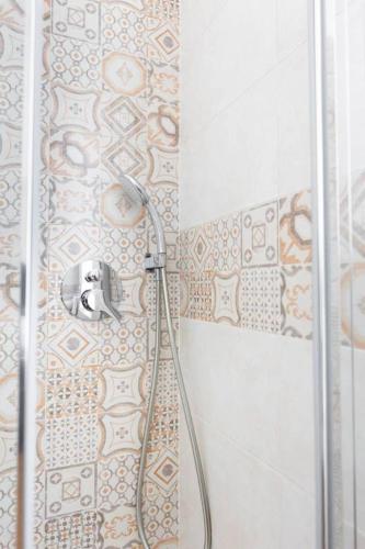 a shower with a hose in a bathroom at Casa Aydée in Bergamo